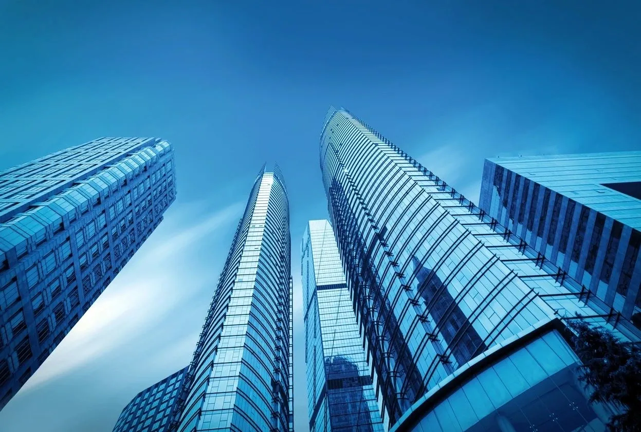 A group of tall buildings with blue sky in the background.